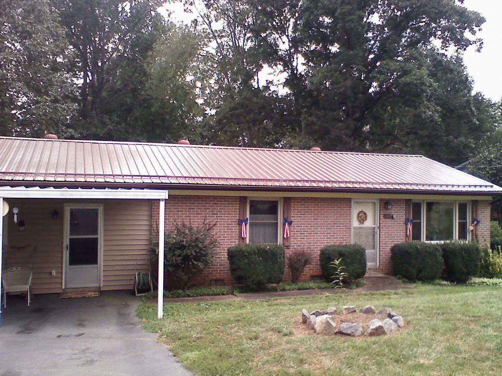 Bronze metal roof and carport on a brick ranch home — Roof Repair work by our crew in Ellettsville